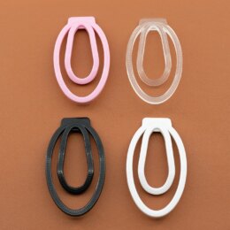 Four colorful oval-shaped plastic clips on brown surface.