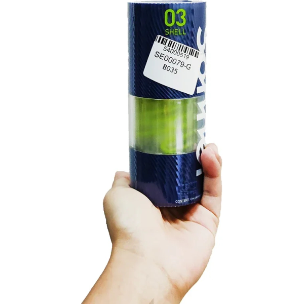 Hand holds cylindrical object with label.